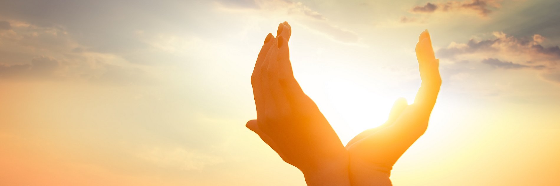 hands holding the sun at dawn
